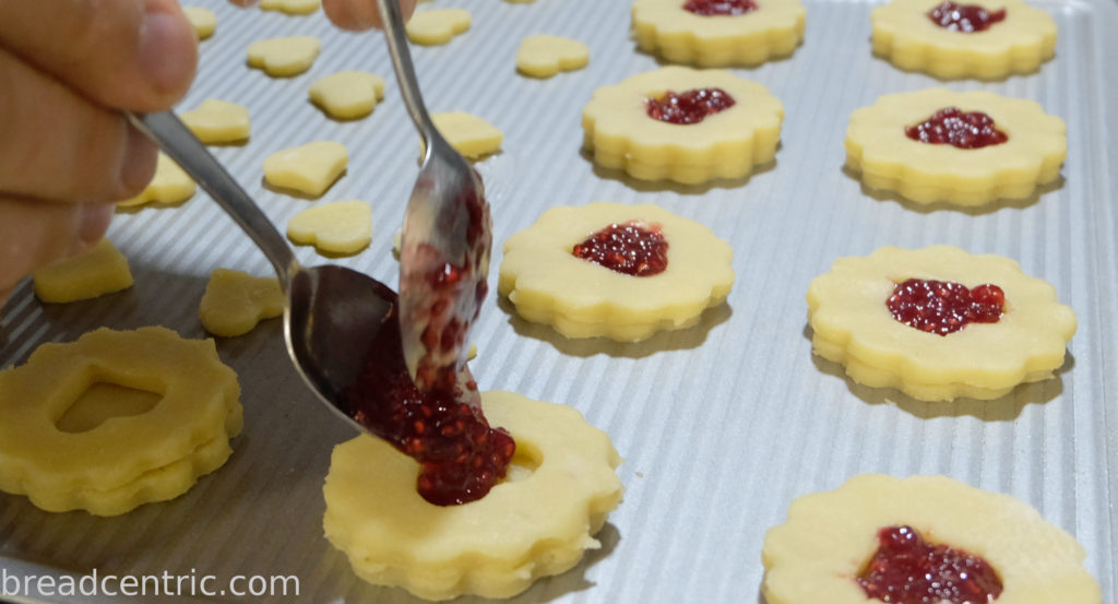 Putting jam into a biscuit